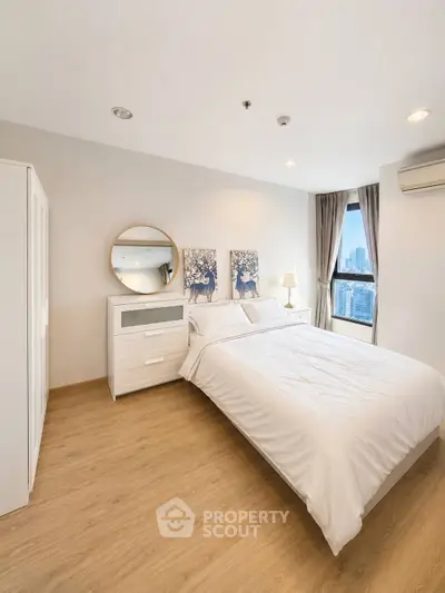 Modern bedroom with city view, featuring elegant decor and natural light.
