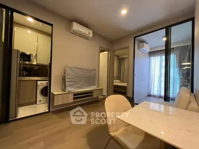 Modern apartment interior with open living room, kitchen, and dining area featuring sleek design and natural light.