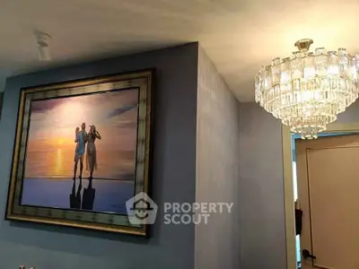 Elegant interior with chandelier and framed artwork in a modern living space.