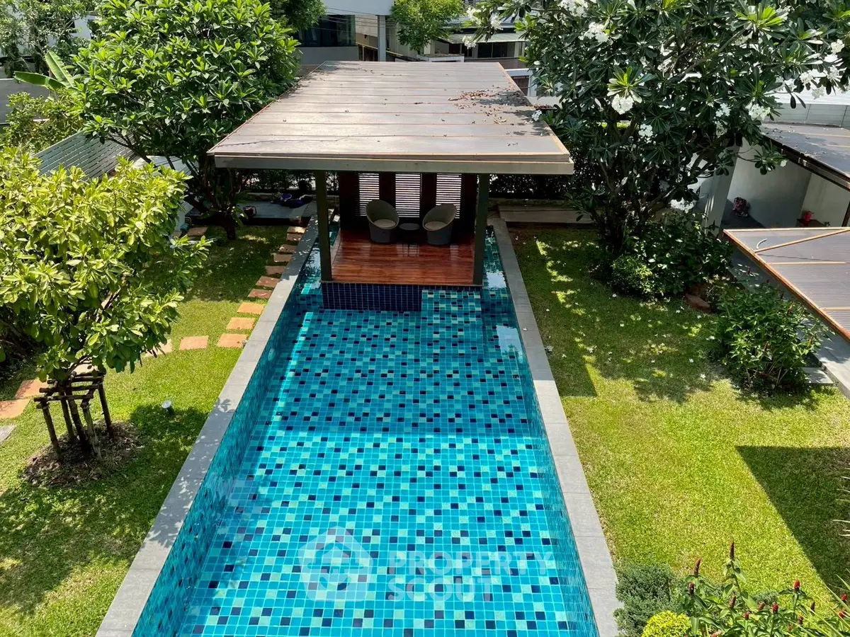 Luxurious private pool with lush garden and stylish gazebo, perfect for relaxation and entertainment.