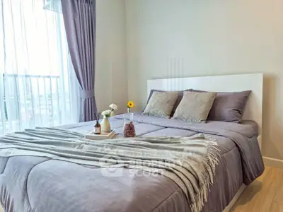 Modern bedroom with cozy bedding and city view from large window