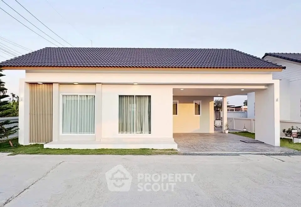 Modern single-story house with a spacious driveway and sleek exterior design.
