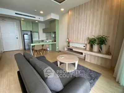 Modern living room with open kitchen, stylish decor, and cozy seating area in a contemporary apartment.