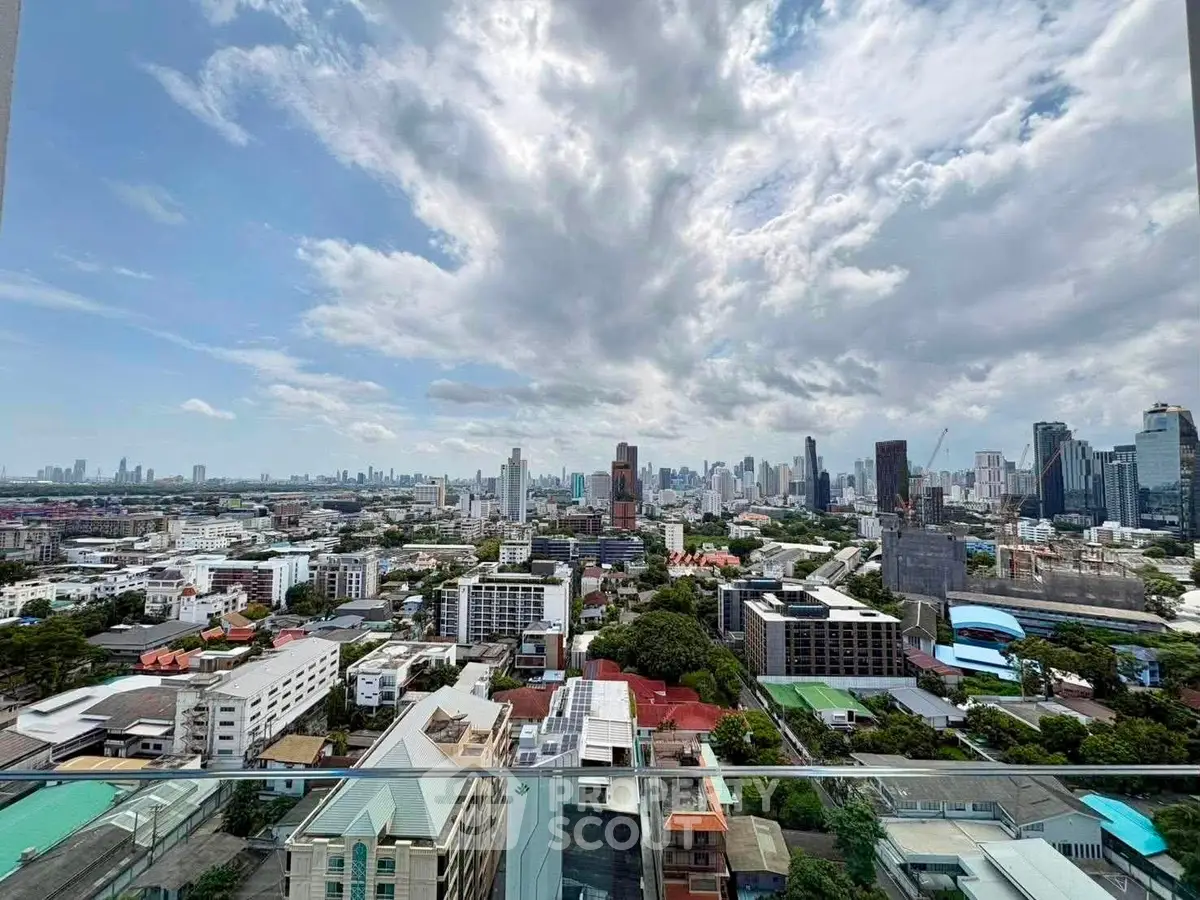 Stunning cityscape view from a high-rise balcony showcasing urban skyline and expansive sky.