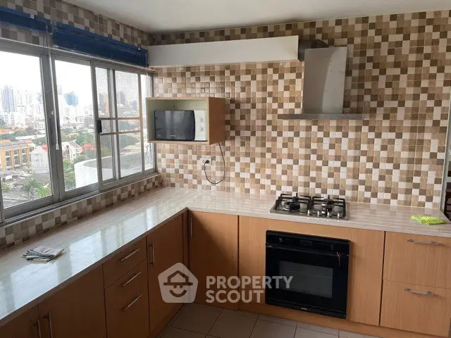 Modern kitchen with city view, featuring gas stove and built-in oven, ideal for urban living.