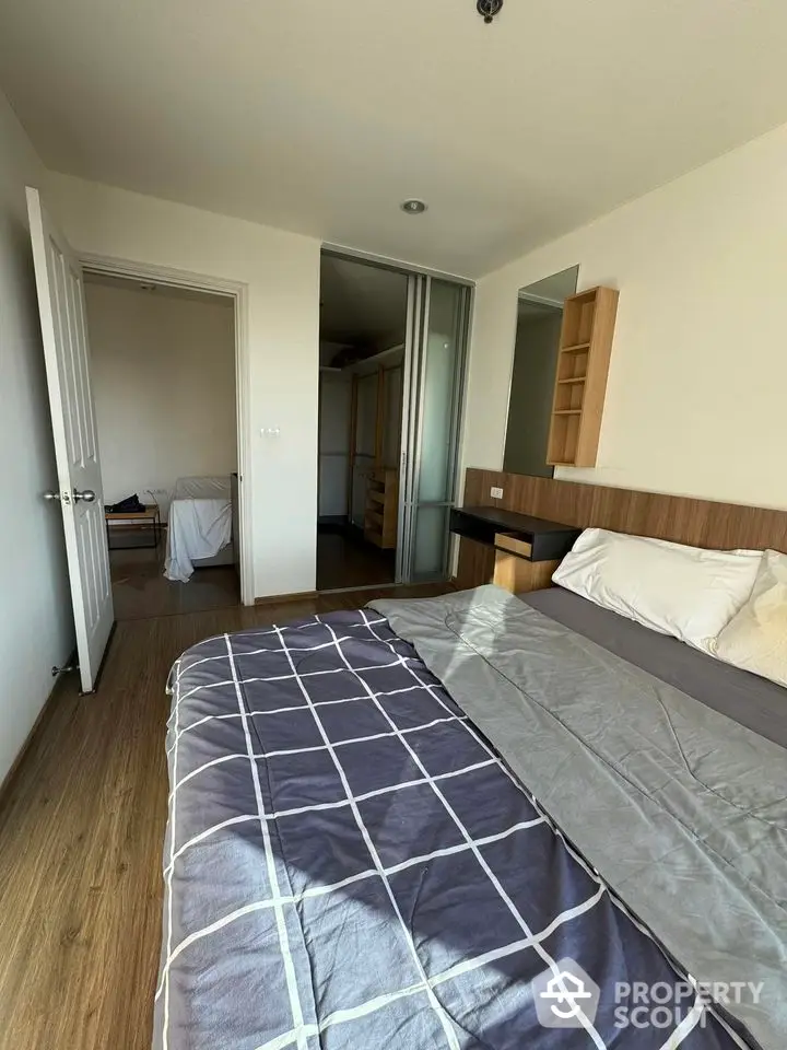 Modern bedroom with wooden flooring and stylish bedding in a cozy apartment