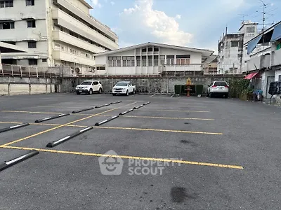 Spacious urban parking lot with multiple parking spaces and surrounding buildings.