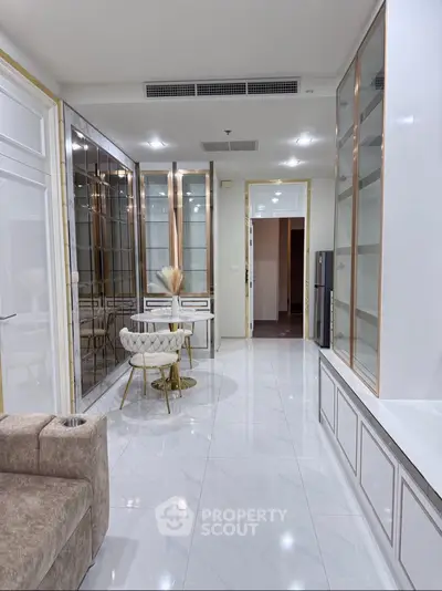 Luxurious modern living room with elegant decor and glossy white flooring, featuring stylish furniture and built-in shelving.