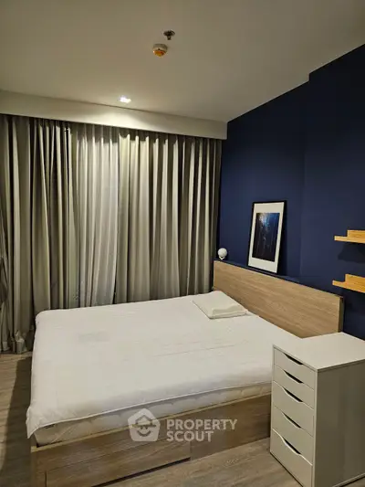Modern bedroom with stylish decor and cozy ambiance, featuring a comfortable bed and elegant curtains.
