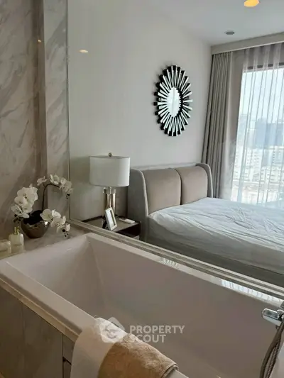 Luxurious bedroom with en-suite bathroom featuring a modern bathtub and elegant decor.