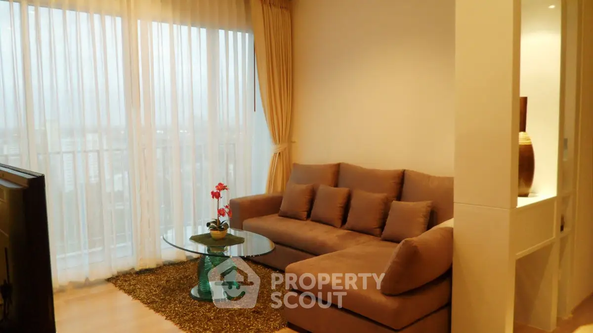 Elegant living room with plush sofa and city view through sheer curtains