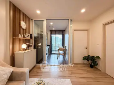 Modern living room with wooden flooring and stylish decor leading to a cozy kitchen area.