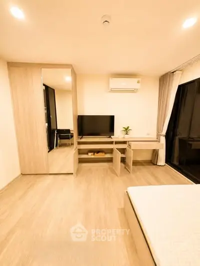 Modern bedroom with built-in wardrobe and TV, featuring sleek design and warm lighting.