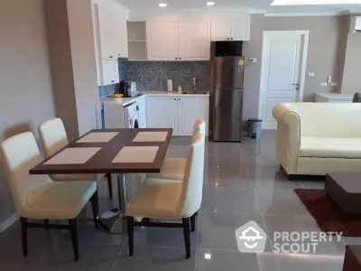 Modern open-layout kitchen and dining area with sleek appliances and elegant furniture.