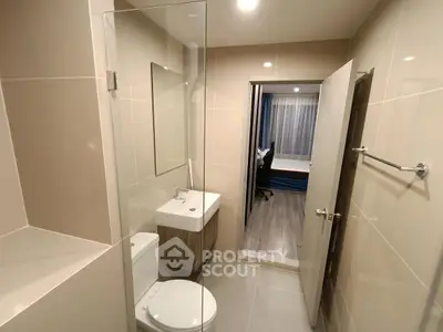 Modern bathroom with glass shower and sleek fixtures in contemporary apartment.