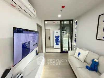 Modern living room with stylish decor and air conditioning, featuring a cozy sofa and wall-mounted TV.