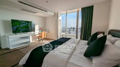 Luxurious bedroom with city view, modern decor, and large TV in high-rise apartment.