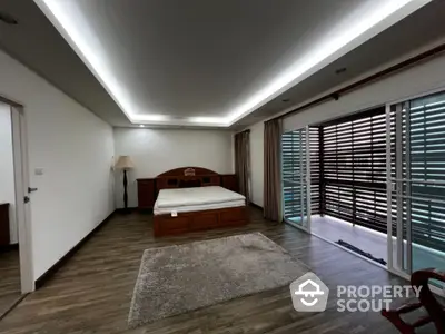 Spacious and elegantly designed bedroom with modern lighting, large windows, and premium wooden flooring, offering a serene and luxurious living experience.