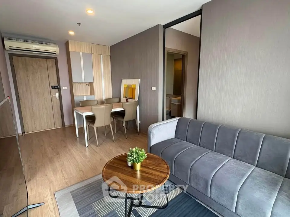 Modern living room with stylish furniture and open dining area in a contemporary apartment.