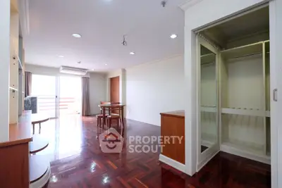 Spacious living room with wooden flooring and open balcony access