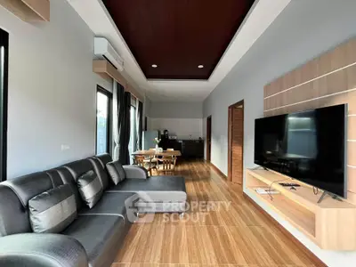 Spacious modern living room with sleek furniture and large TV, open layout design