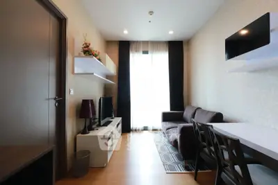 Modern living room with stylish decor and natural light, featuring a cozy sofa and elegant shelving.