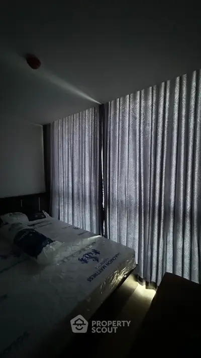 Cozy bedroom with large windows and elegant curtains, perfect for relaxation and comfort.