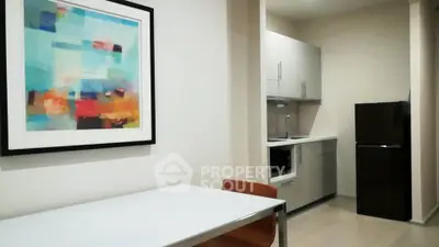 Modern kitchen with sleek cabinets and vibrant wall art in a cozy apartment.