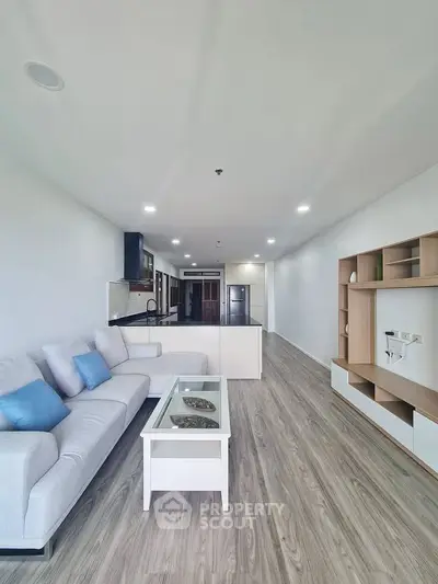 Spacious modern living room with sleek design and open layout, featuring stylish furniture and elegant flooring.