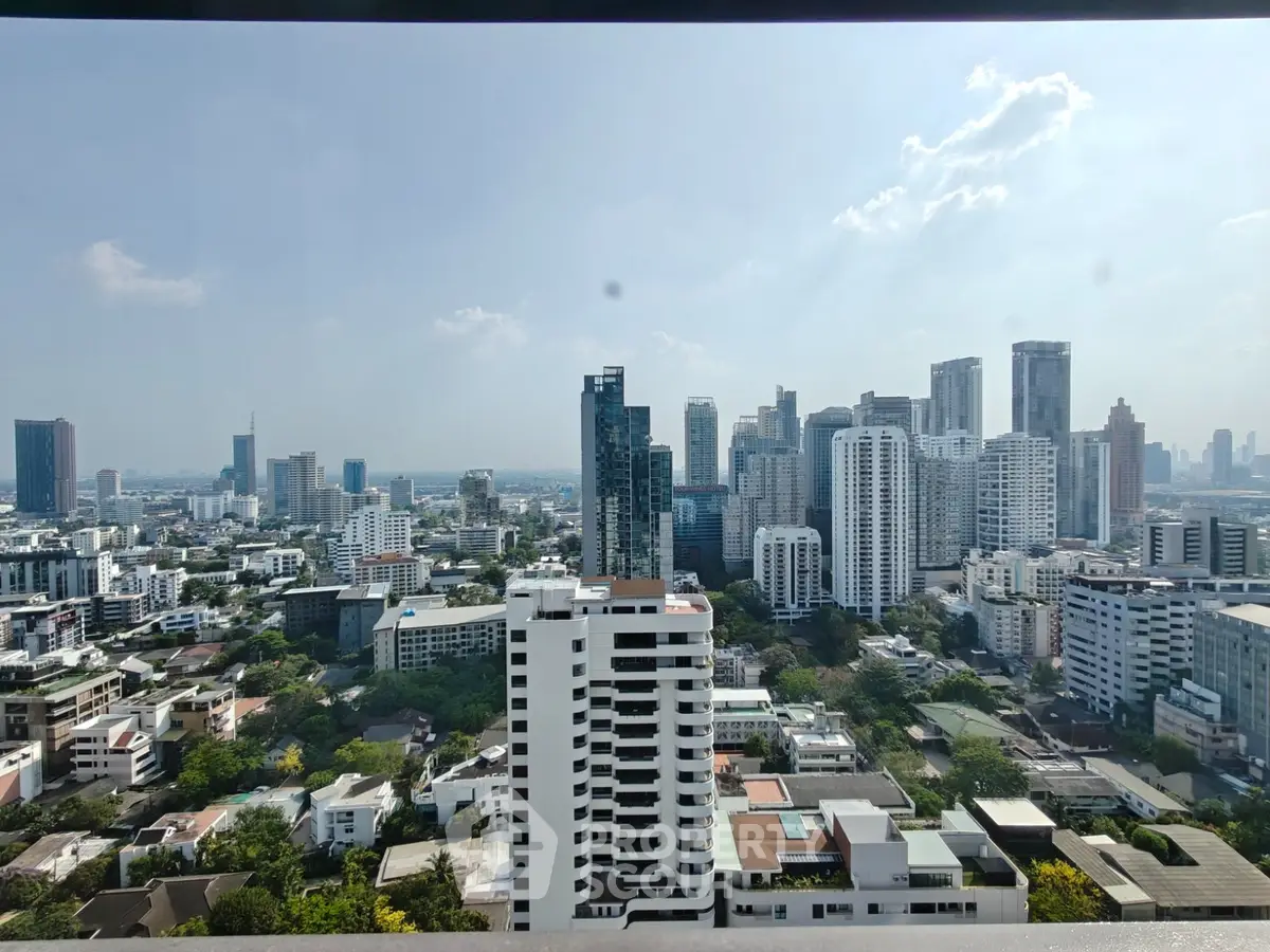 Stunning cityscape view from a high-rise building showcasing modern urban skyline and lush greenery.