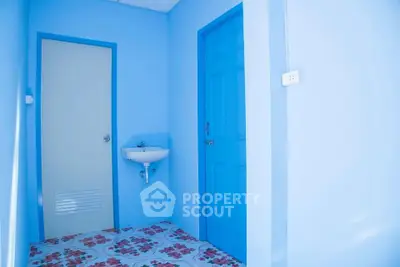 Bright blue bathroom with floral tile flooring and compact sink