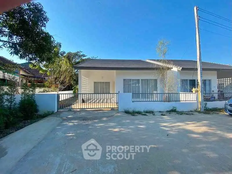 Charming single-story house with spacious driveway and modern exterior design.