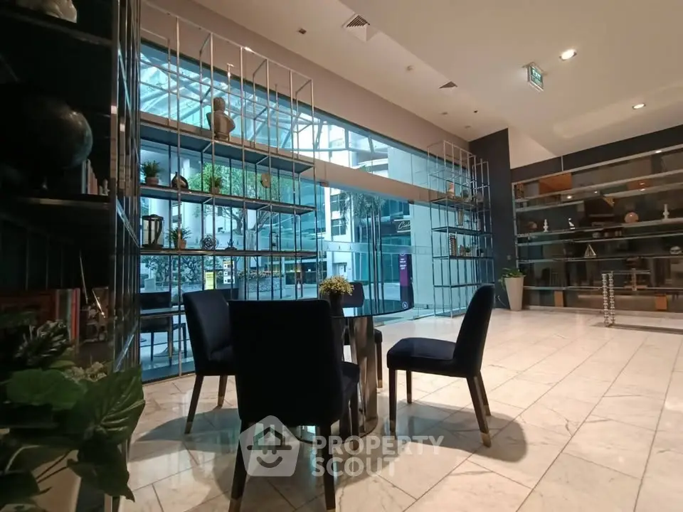 Modern lobby with stylish seating and decorative shelving in a contemporary building.