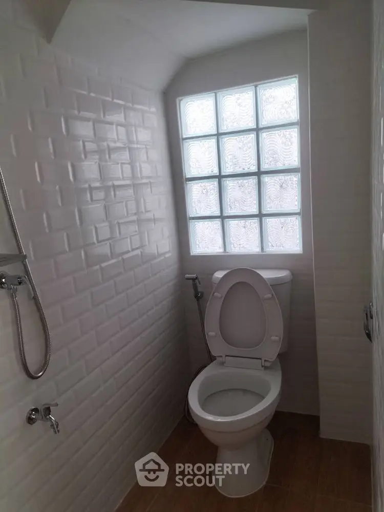 Compact bathroom with modern white tiles and frosted glass window