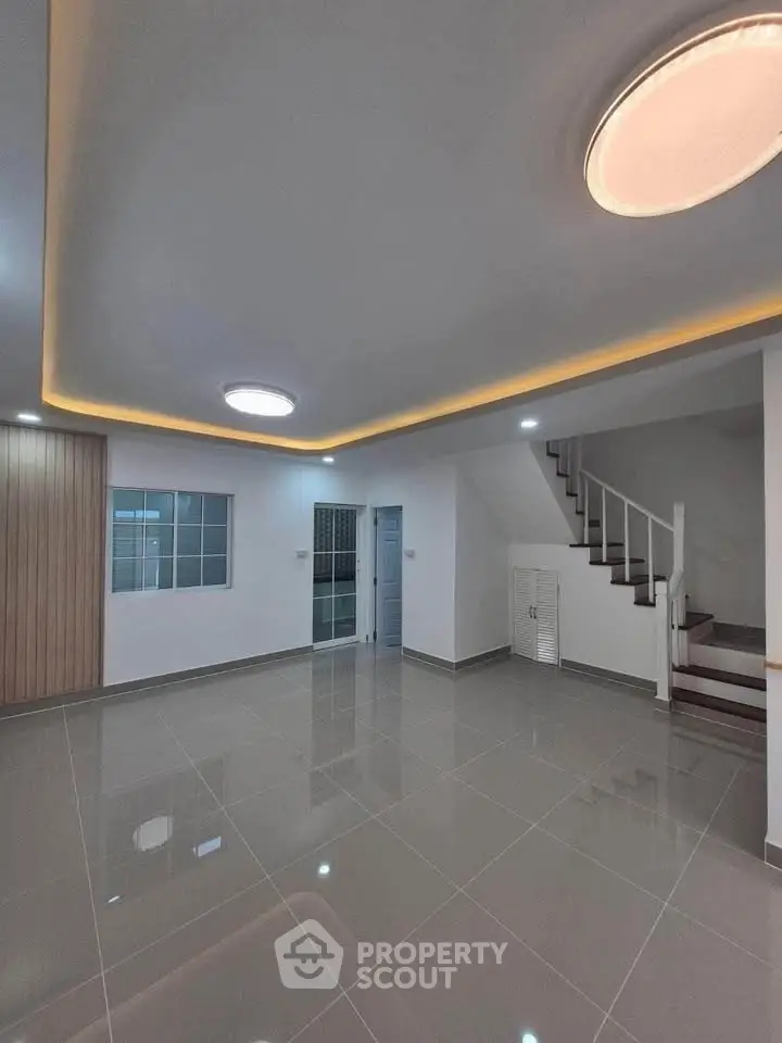 Spacious modern living room with sleek staircase and elegant lighting