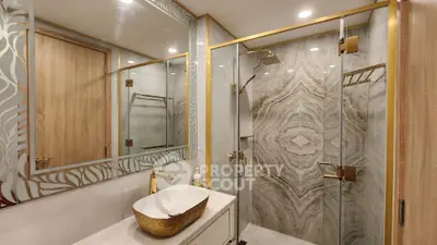 Luxurious bathroom with elegant gold fixtures and modern glass shower