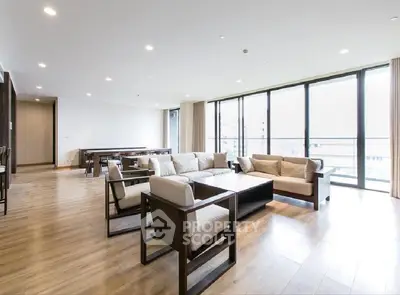 Spacious modern living room with large windows and elegant wooden flooring