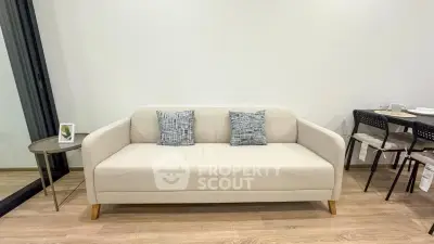 Modern living room with stylish beige sofa and dining area, perfect for cozy urban living.