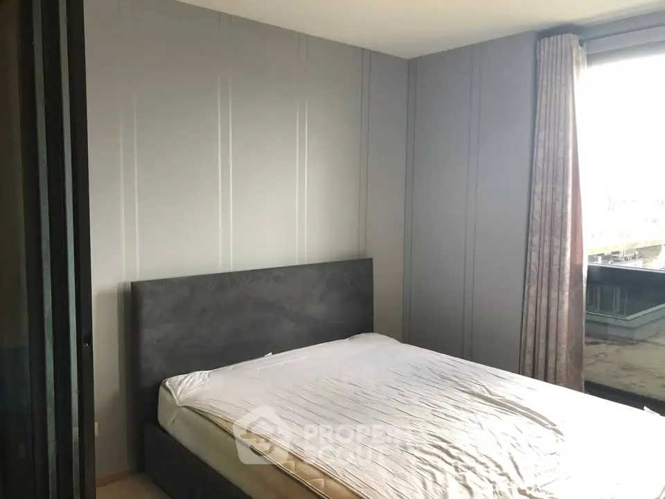Modern bedroom with sleek design and large window offering natural light.