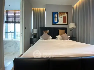 Modern bedroom with elegant decor and adjacent bathroom view.