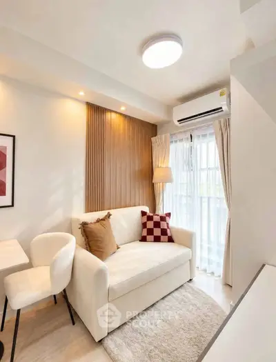 Modern living room with cozy sofa, stylish decor, and natural light through large window.