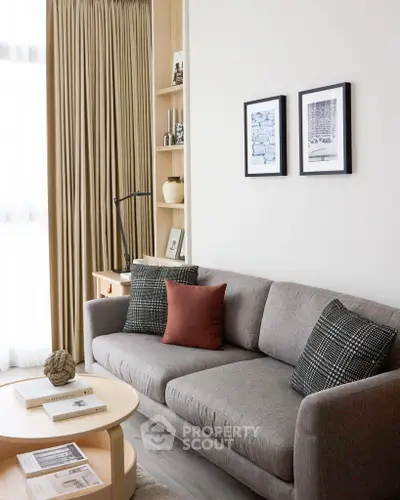 Cozy living room with modern gray sofa, stylish decor, and natural light.