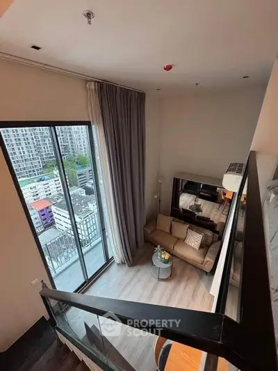 Stunning high-rise living room with floor-to-ceiling windows and city view balcony.