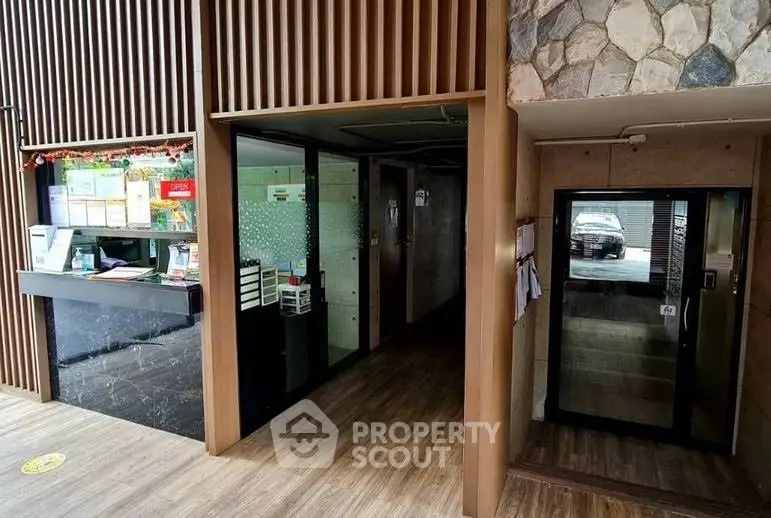 Modern building entrance with stylish wood paneling and stone accents