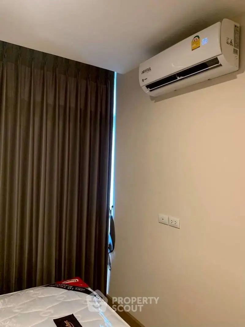 Cozy bedroom with air conditioning and elegant curtains, perfect for comfortable living.