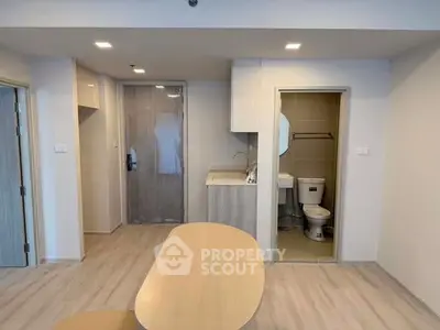 Modern apartment interior with compact kitchen and bathroom, featuring sleek design and efficient layout.