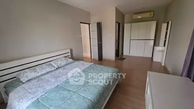 Spacious bedroom with modern furnishings and ample storage in a stylish apartment.