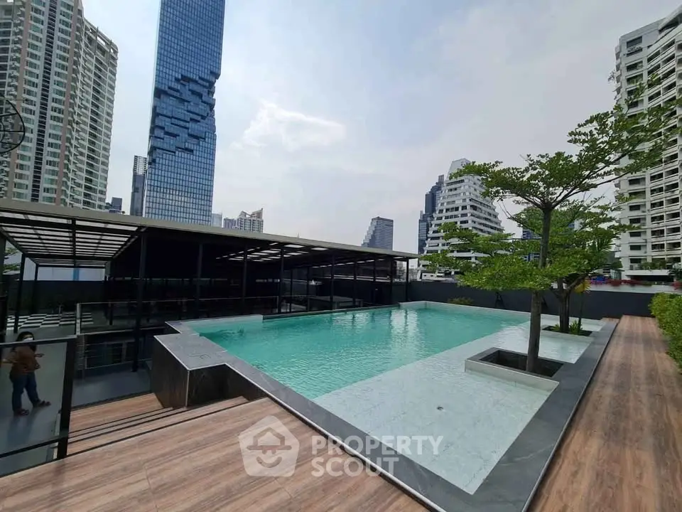 Luxurious rooftop pool with stunning cityscape views in modern high-rise building.
