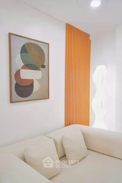 Modern living room with abstract art and cozy beige sofa