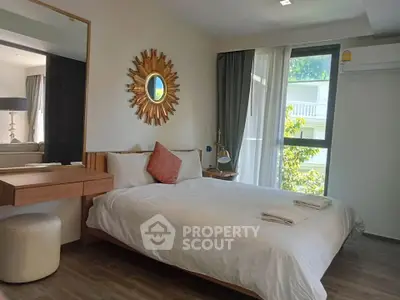 Modern bedroom with stylish decor and large window offering natural light
